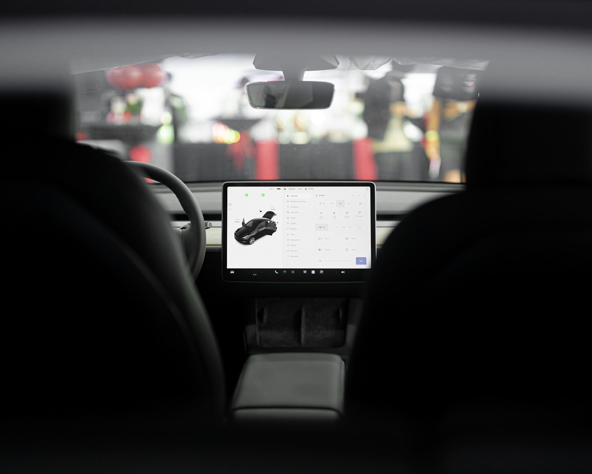 Interior view of a modern car with a central touchscreen display showing vehicle controls and settings